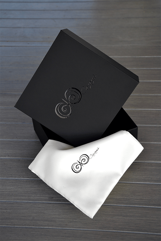 Emballage cadeau Caramì : boîte noire et pochette blanche avec logo.